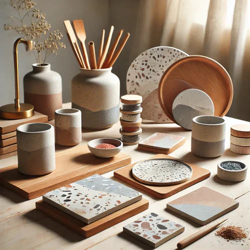 Ensemble d'objets de décoration en jesmonite, incluant des sous-verres terrazzo, des plateaux marbrés et des vases minimalistes, présentés sur une table en bois avec des outils de création DIY et pigments colorés.