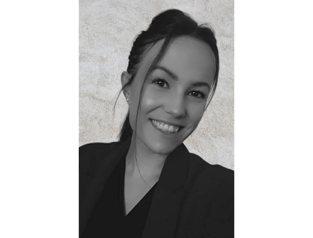 Portrait de Solène, souriante et engageante, donnant un aperçu chaleureux et authentique de sa personnalité. La photo capture son style vestimentaire comme une allure professionnelle en chemise élégante offrant aux visiteurs une première impression amicale et accueillante de qui elle est.